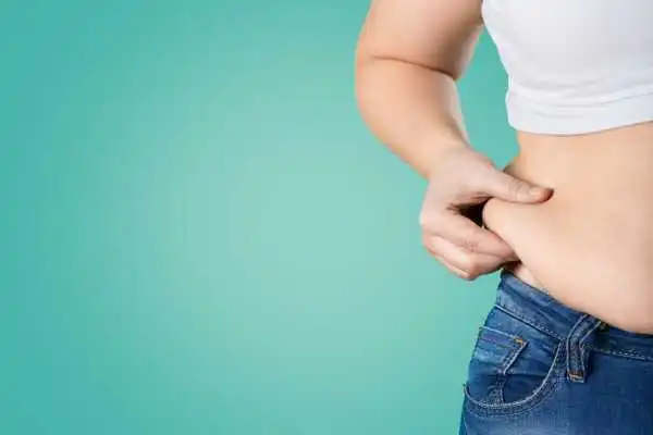 Image of woman pinching her love handles to show weight gain Dunfermline